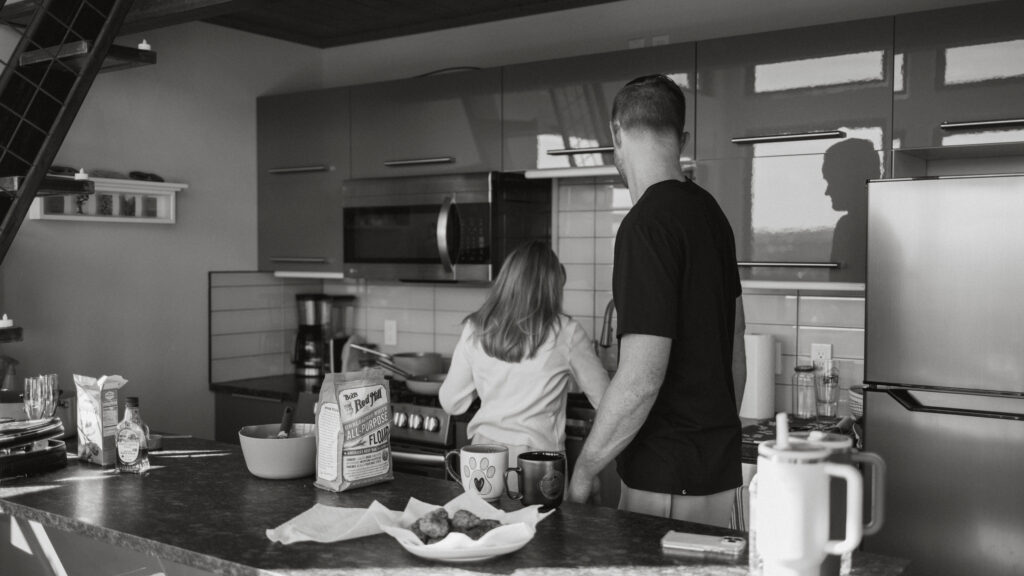 Bride and Groom making pancakes together on their elopement day in their cozy cabin 