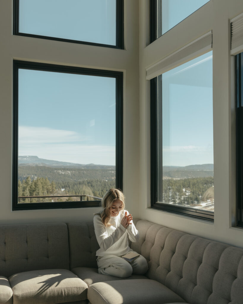 Bride smiling sitting on the couch, mountains in the background

