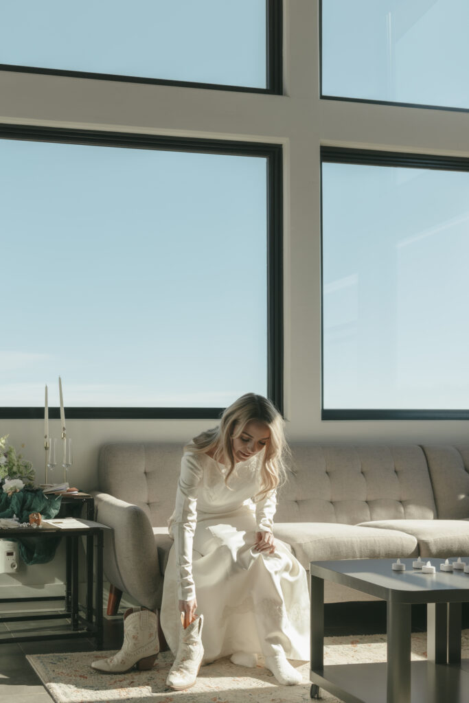Bride putting on her short cowgirl boots to wear with her wedding dress