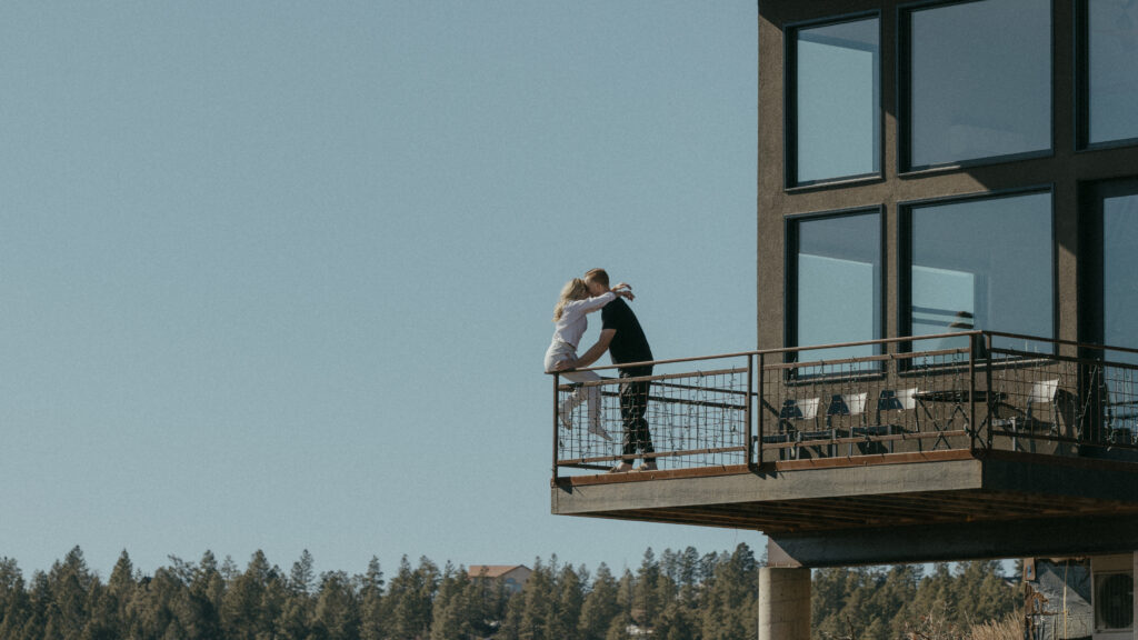 Bride sitting on the edge of Airbnb balcony in Pagosa Springs, Colorado