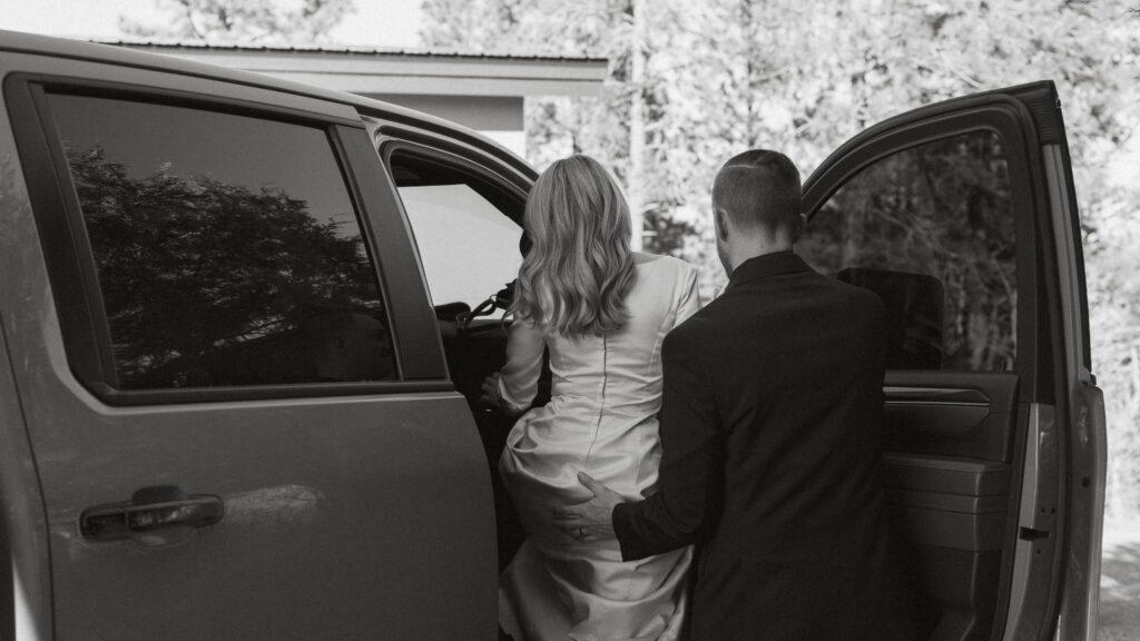 Groom helping bride get into the truck