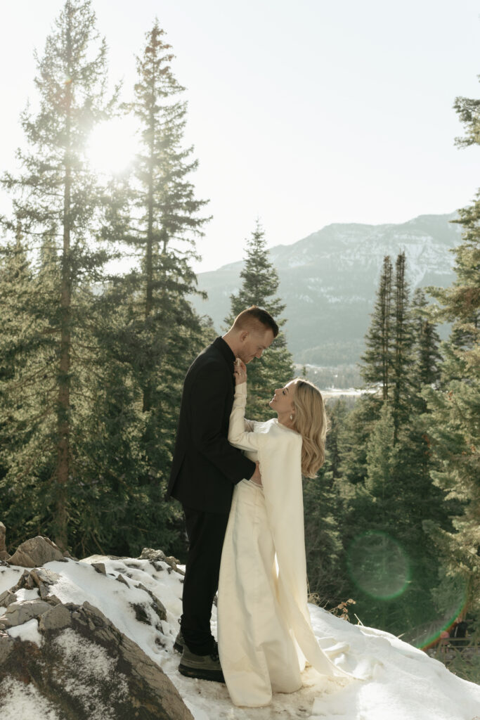 Bride adjusting groom's tie at the top of the mountain