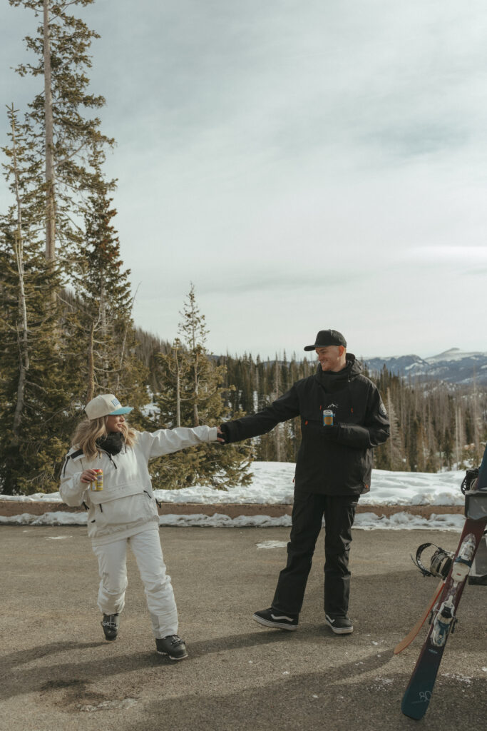 Bride and Groom spinning around in the parking lot at the ski area