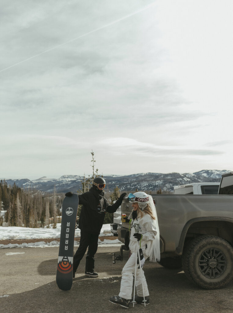 Bride and Groom grabbing their snowboard and skis to head up to the mountain