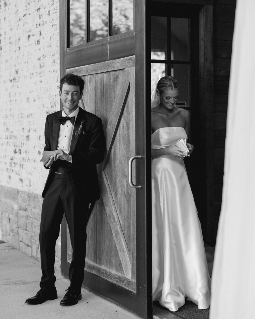 Bride reading handwritten vows outside barn doors at Trinity View Farm wedding