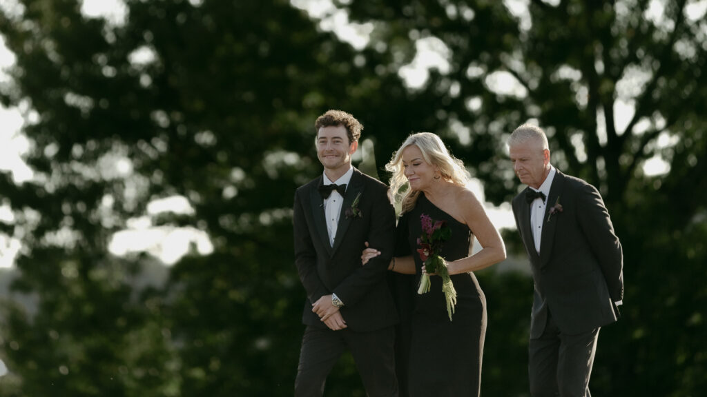 Groom walking with mother down aisle during outdoor ceremony at Trinity View Farm wedding in Franklin Tennessee