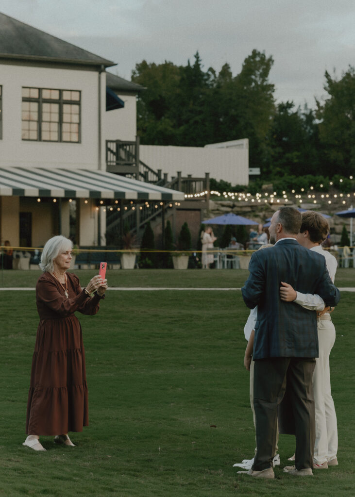 grandma taking photo on her kids standing outside