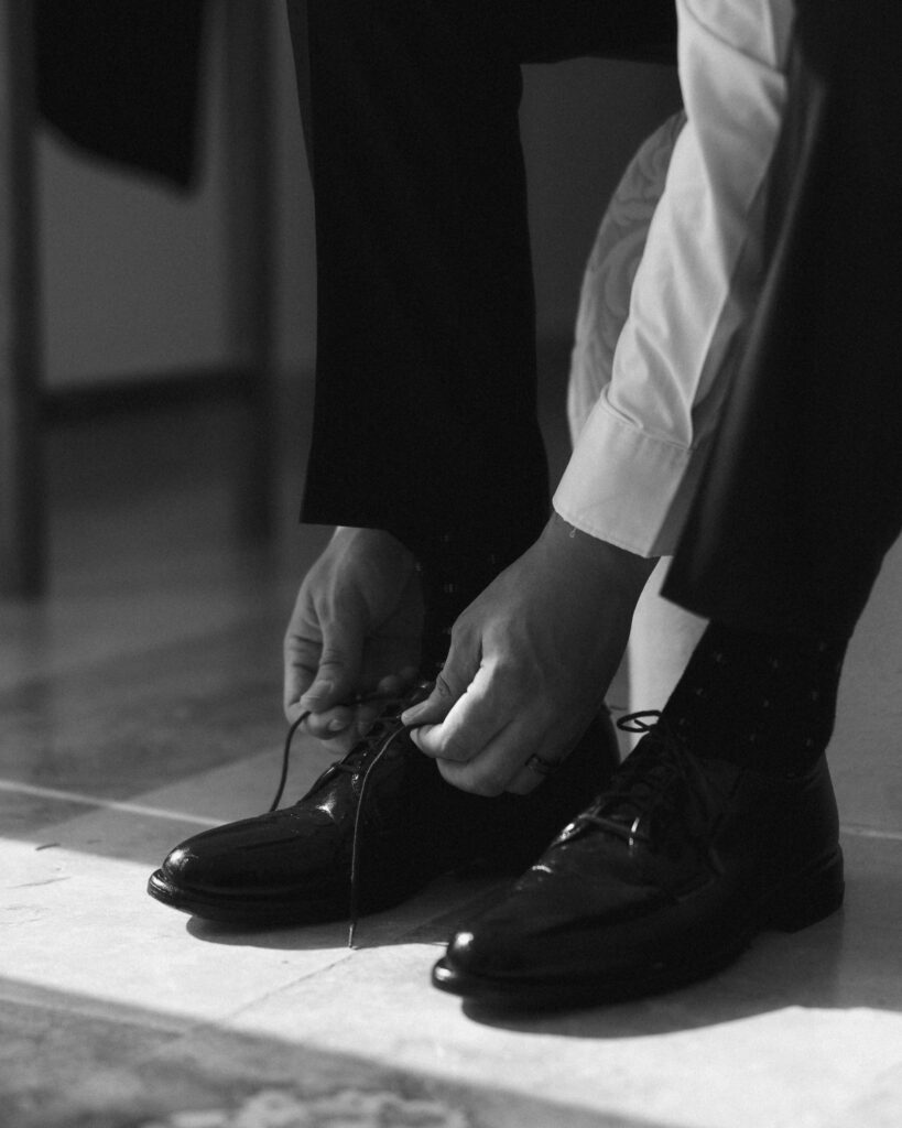 groom tying dress shoes wedding day detail destination wedding Mexico groom getting ready