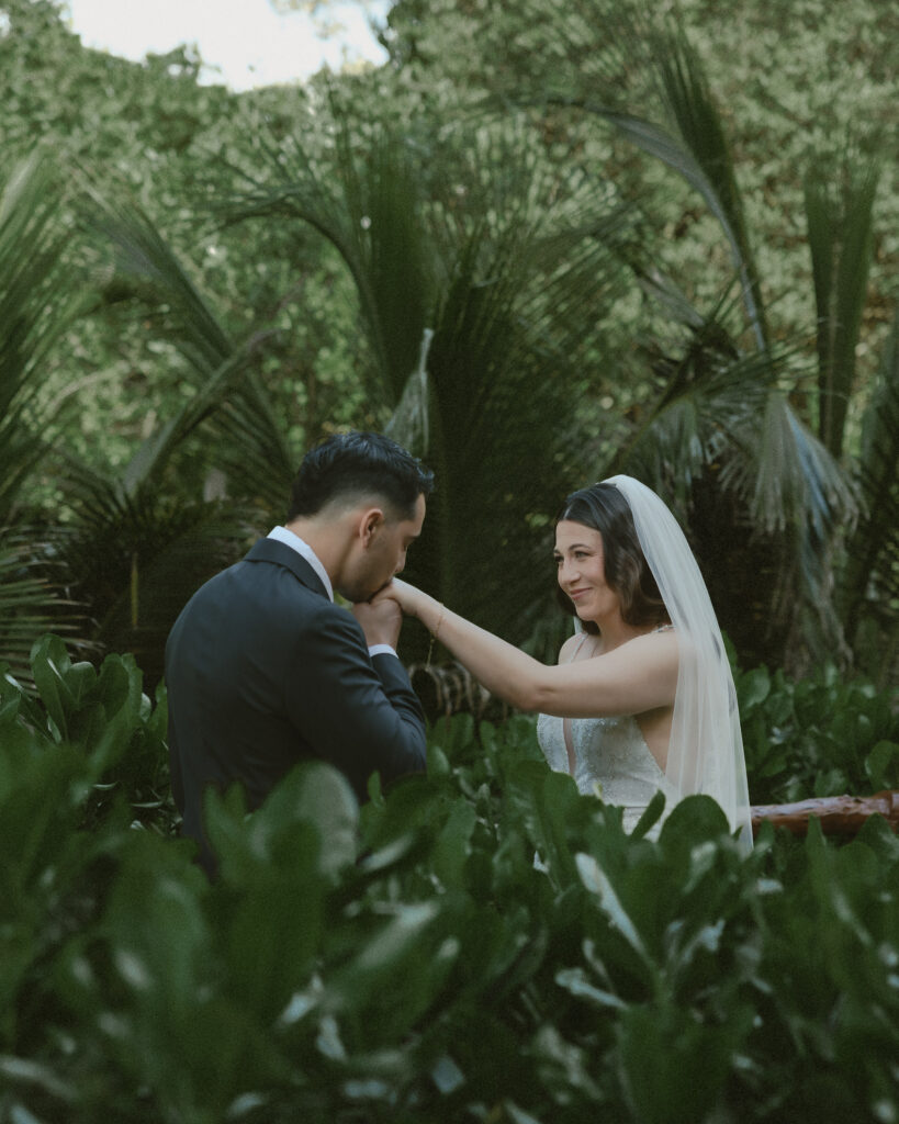 groom kissing bride hand romantic portrait tropical destination wedding Mexico jungle setting