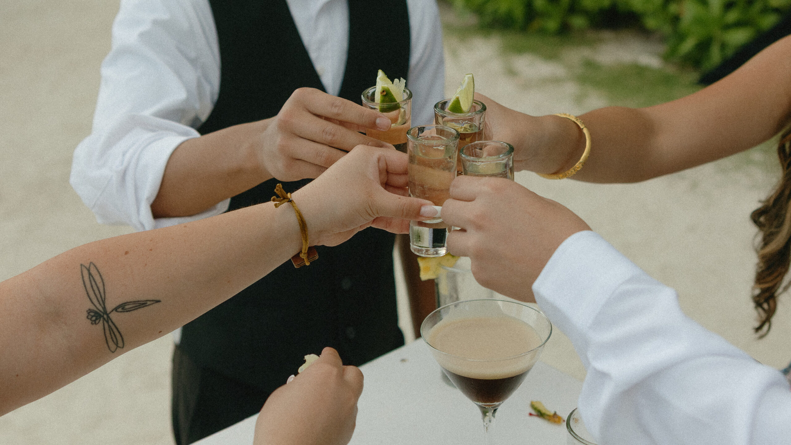 wedding guests taking tequila shots lime destination beach wedding Mexico cocktail hour celebration