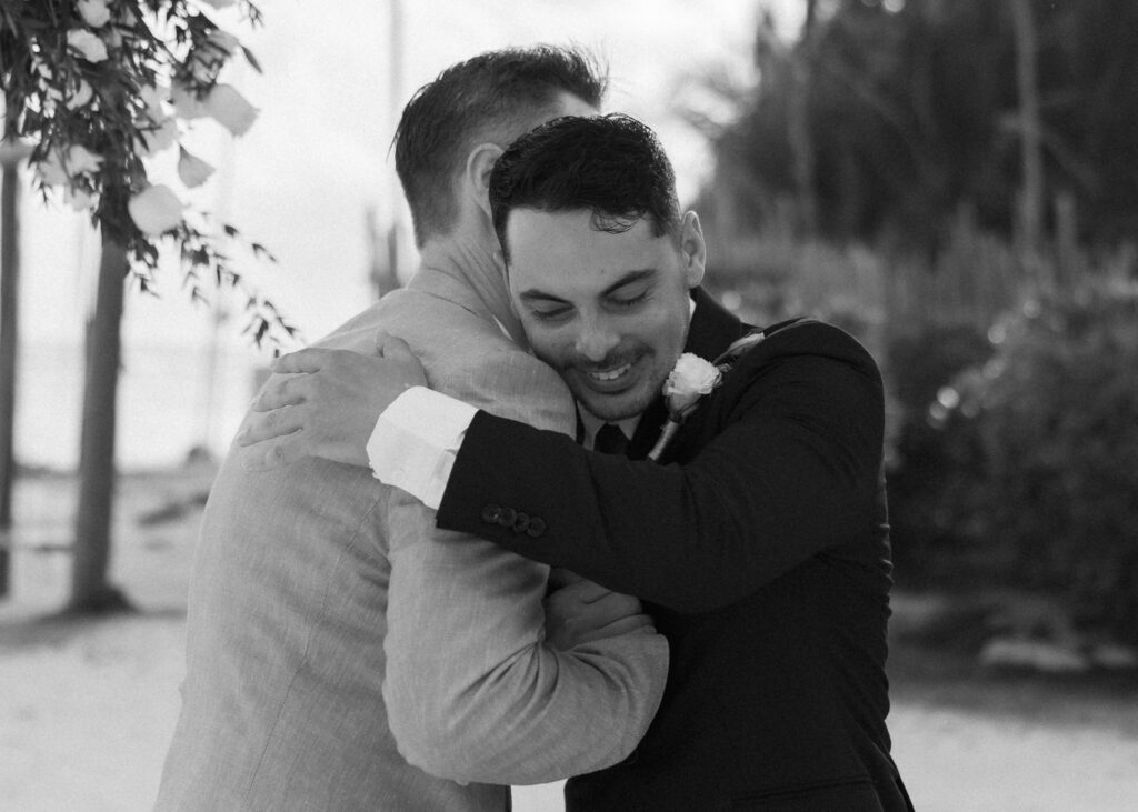 groom hugging family member emotional candid moment destination wedding Mexico