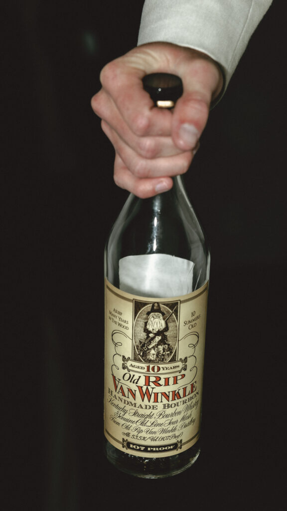 groom holding bottle of pappy van winkle