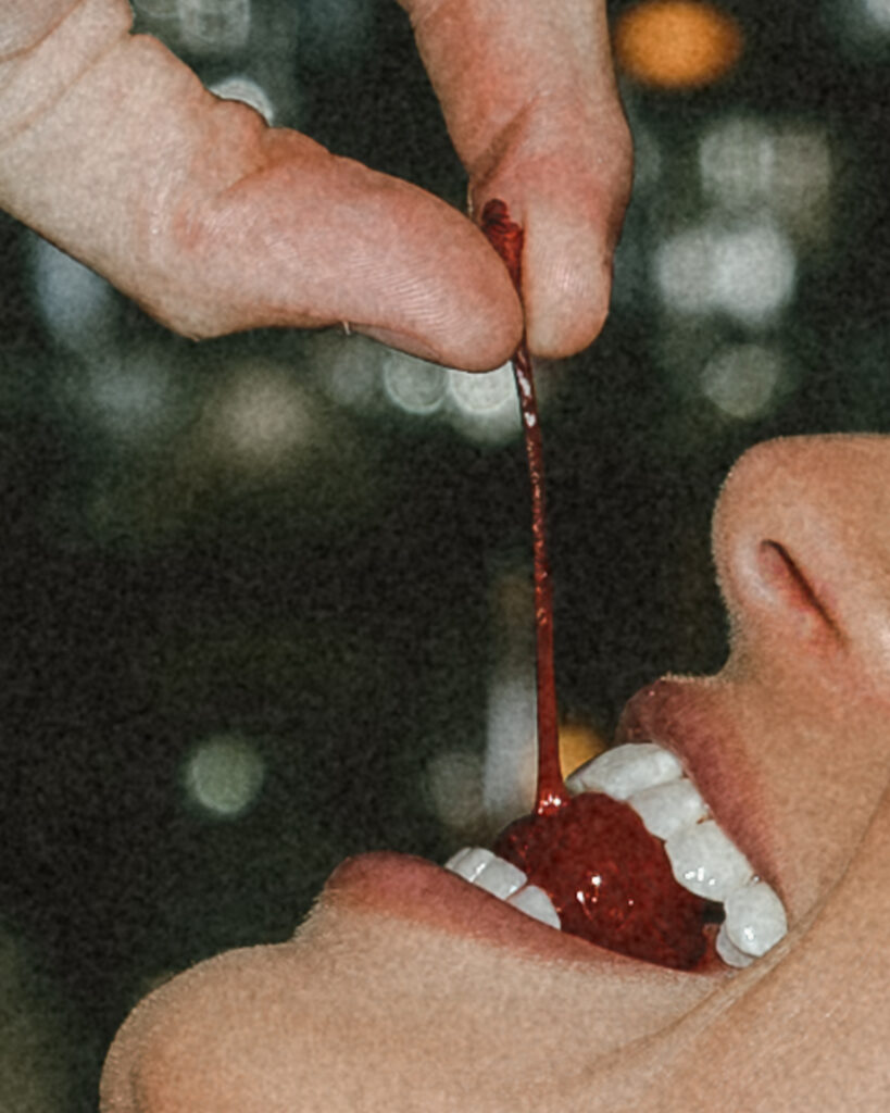 groom feeding bride a cherry from the bar