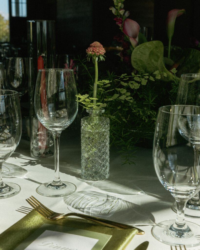 Table placements at the reception with wine glasses, gold fork and flowers