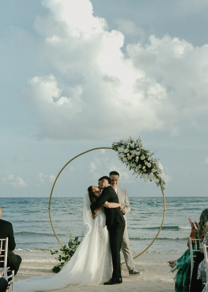 bride and groom first kiss beach wedding Mexico romantic ceremony moment ocean backdrop