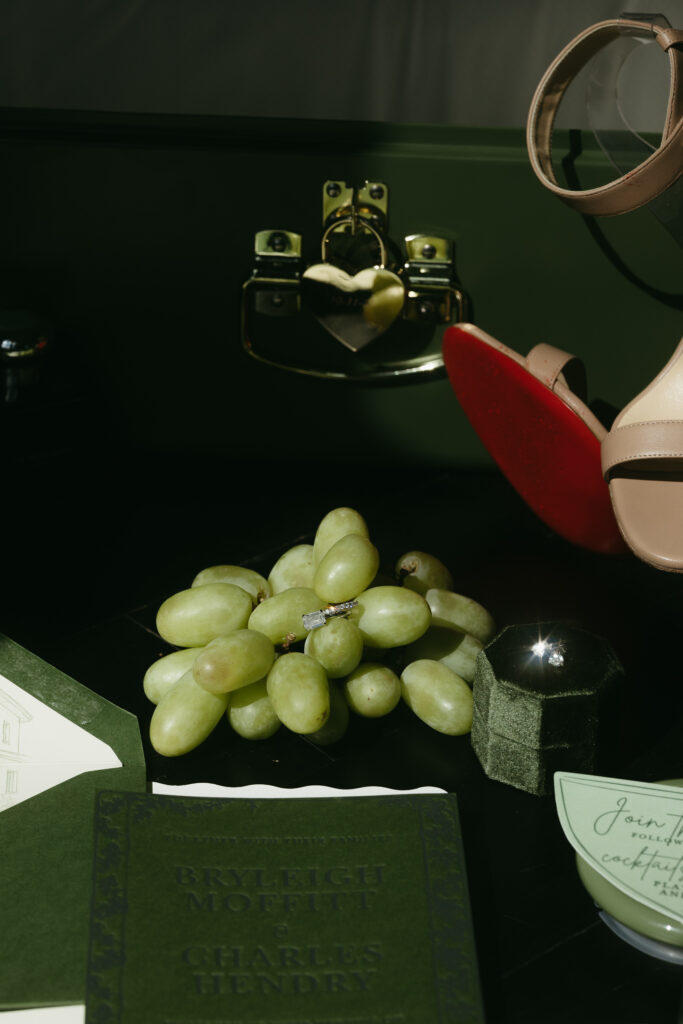 Luxury wedding detail flat lay with grapes, film camera, and invitation suite in Franklin Tennessee