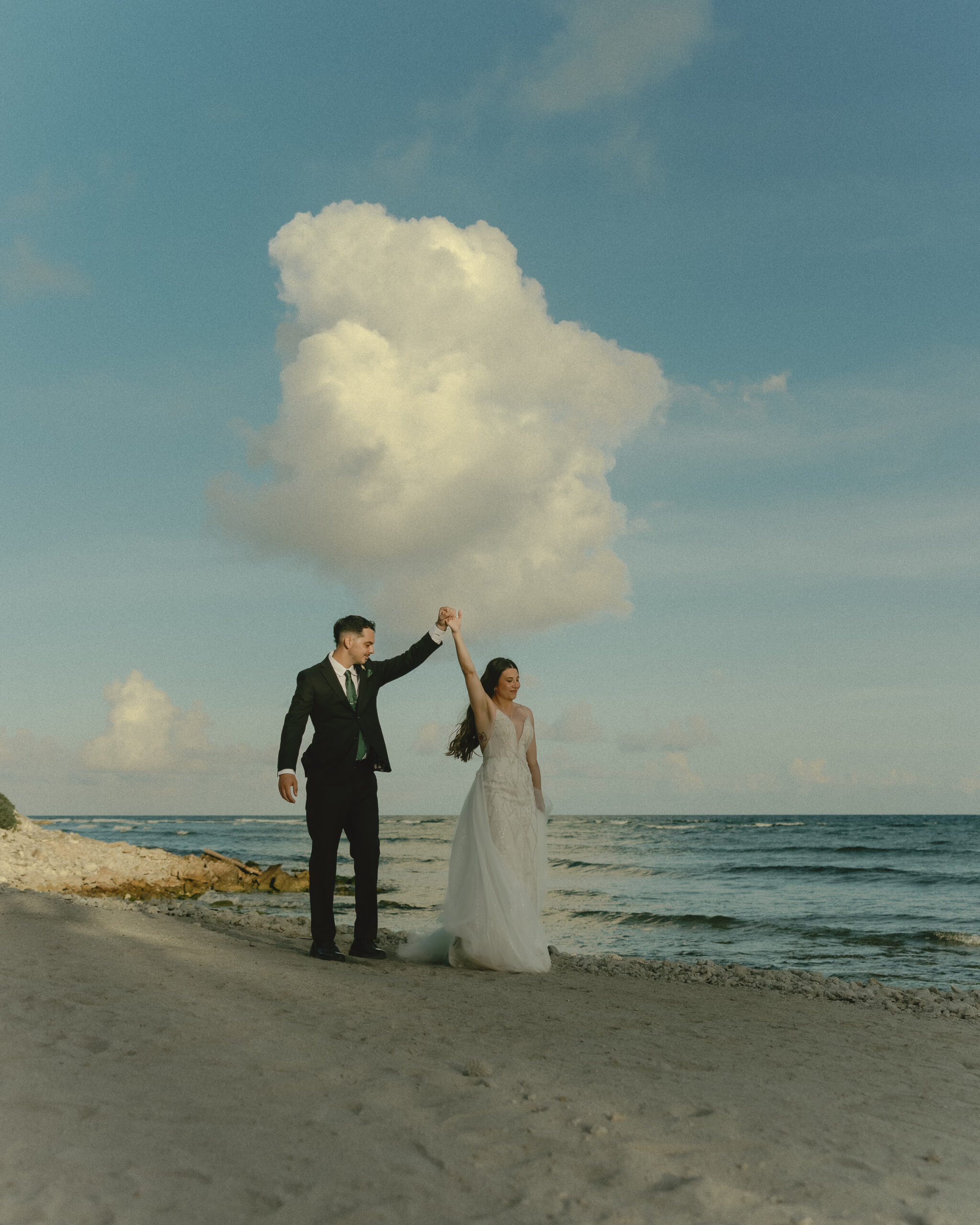 bride and groom walking along beach destination wedding Mexico romantic ocean view portrait
