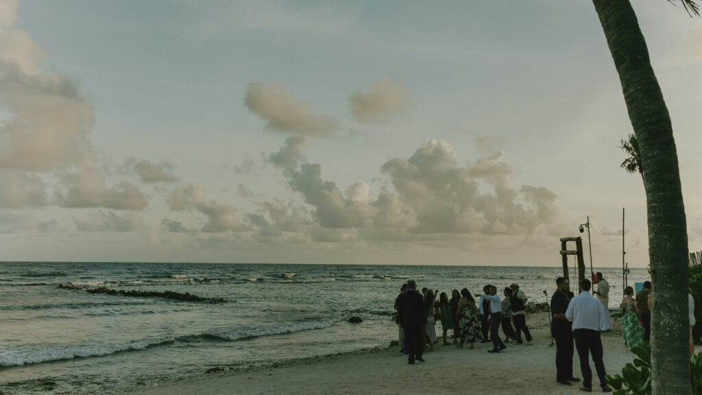 wedding guests gathering on beach at sunset Riviera Maya Mexico destination wedding ocean view