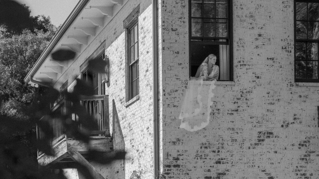 Bride looking outside the window at Trinity View Farm in Franklin Tennessee with her veil blowing in the wind