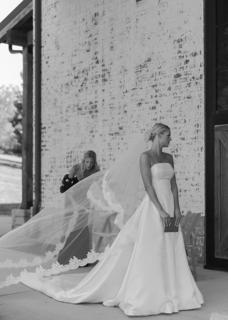 Bride standing outside with long veil and train at Franklin Tennessee wedding venue
