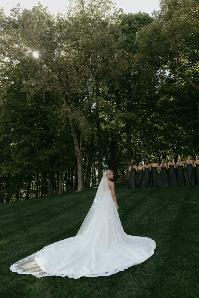 Bride standing on hill with long train during elegant Franklin Tennessee wedding portraits