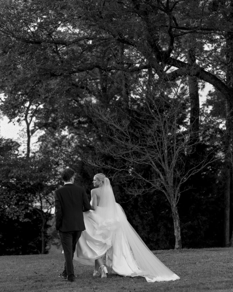 Bride and groom walking away together through trees after ceremony in Franklin Tennessee