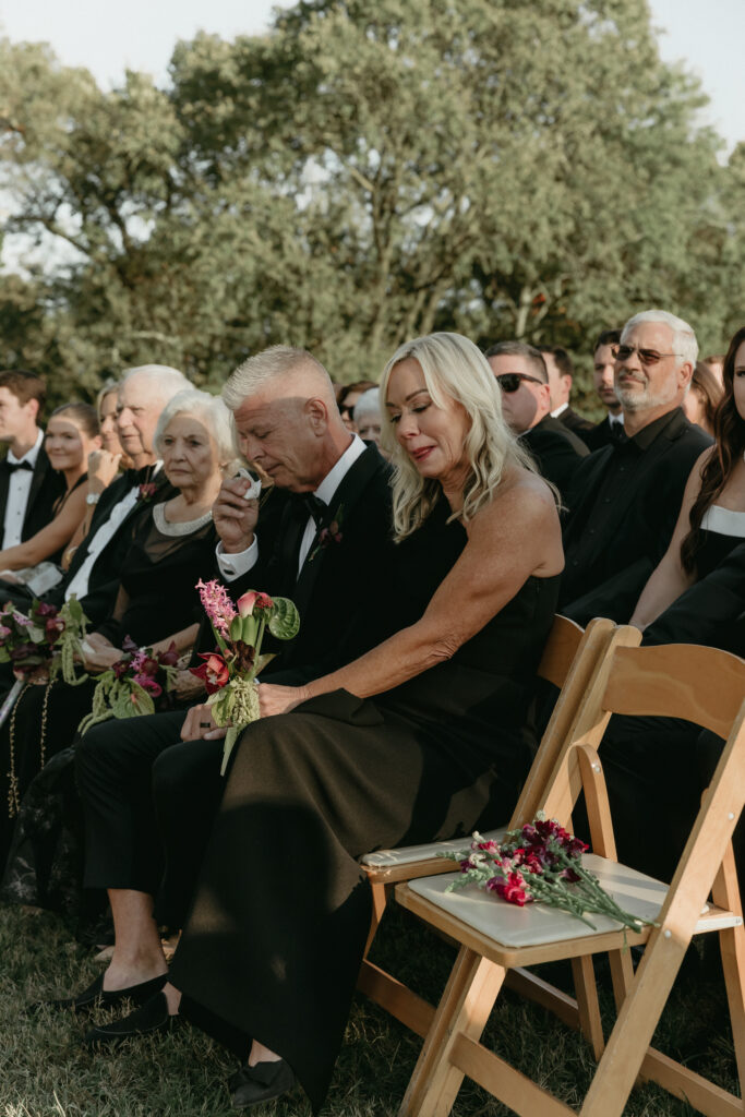 Mother of the groom seated and emotional during ceremony at Trinity View Farm wedding