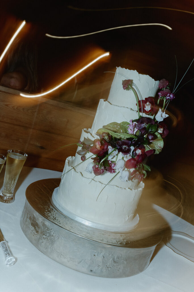 Wedding cake with floral design displayed at reception in Franklin Tennessee