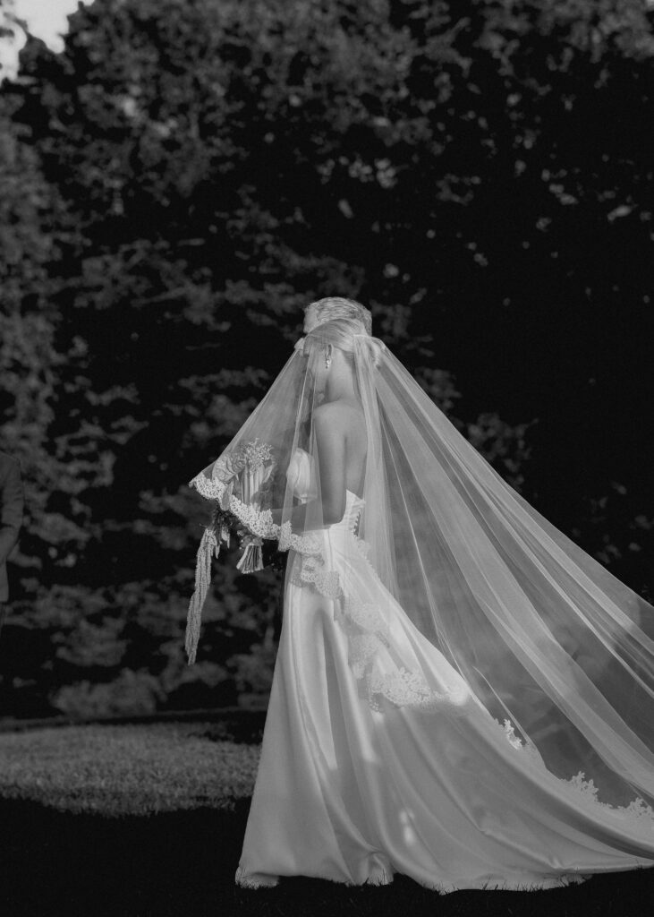 Bride walking with long veil during outdoor ceremony at Trinity View Farm in Franklin TN