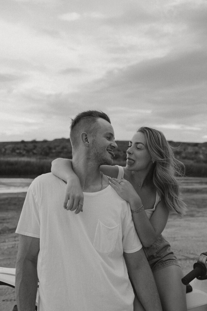 Intimate black and white engagement portrait of couple laughing together outdoors
