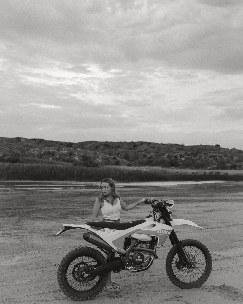 Bride sitting on dirt bike in black and white engagement session in Texas