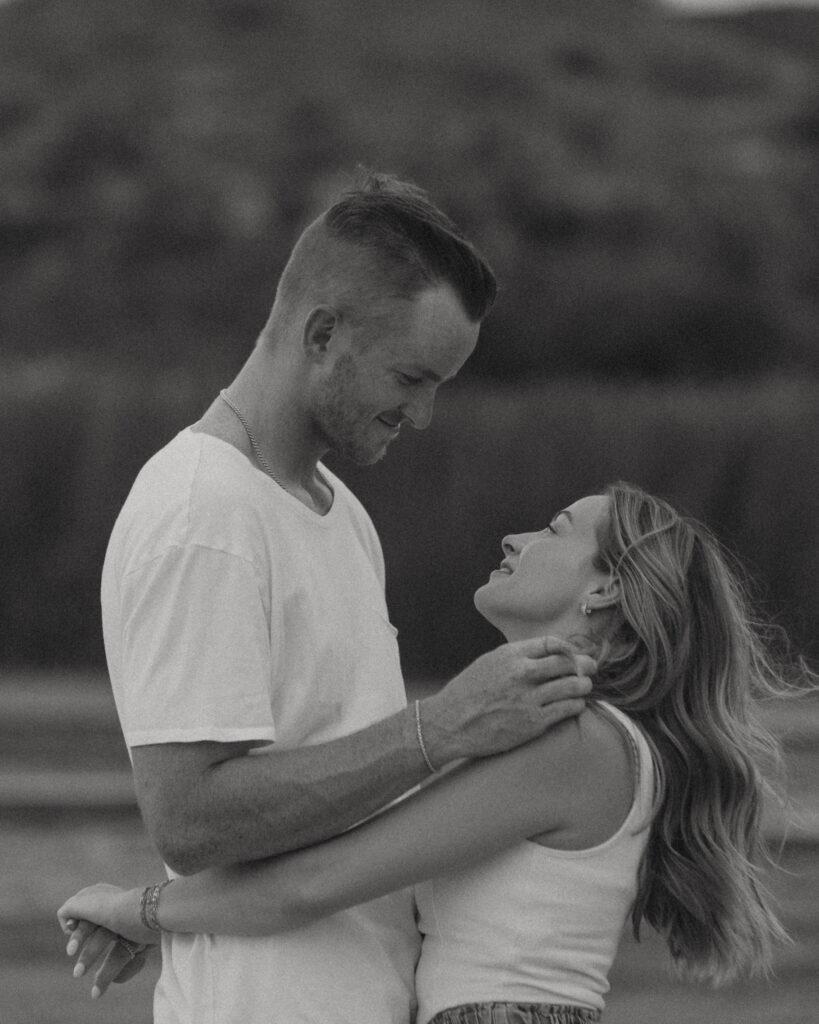 Romantic close-up engagement photo of couple smiling together outdoors