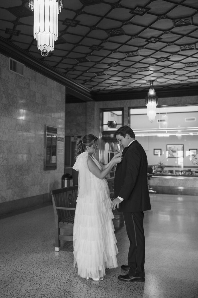bride fixing groom jacket inside amarillo courthouse art deco interior